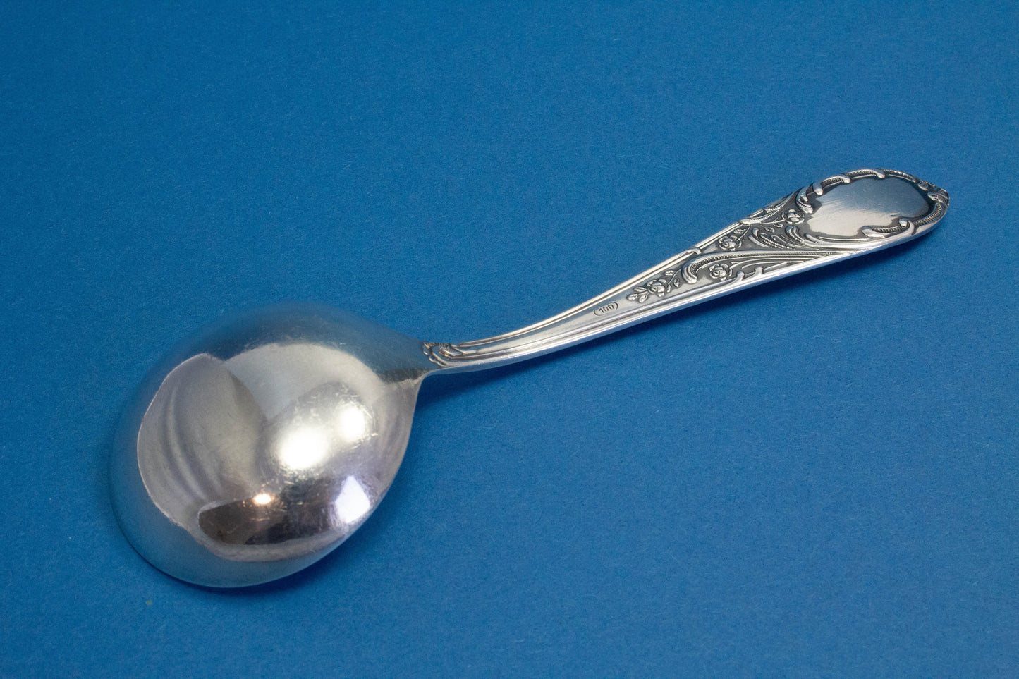 Versilberter Sahnelöffel mit Rokoko-Verzierungen
