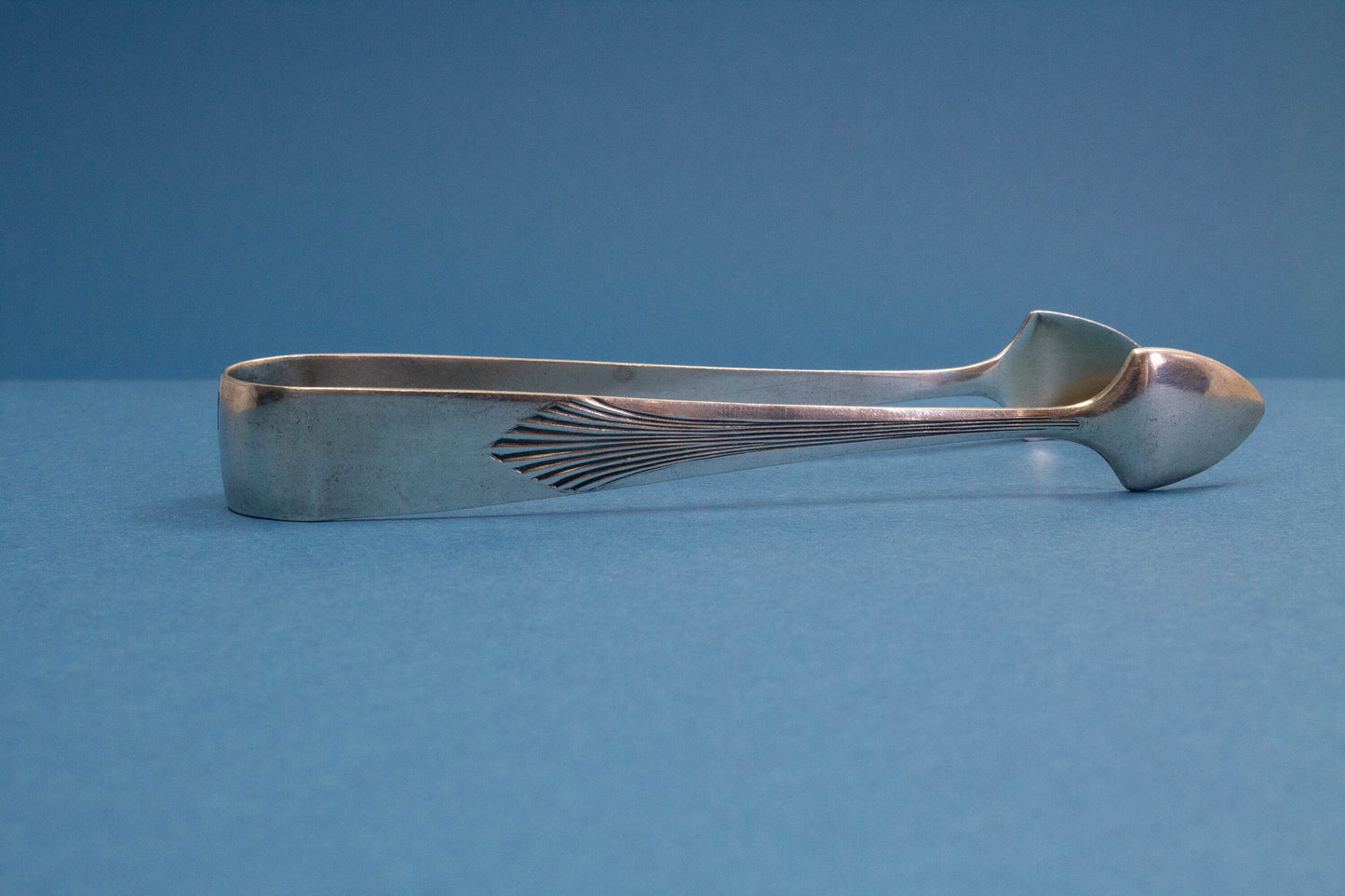 Silver plated sugar tongs with art deco pattern